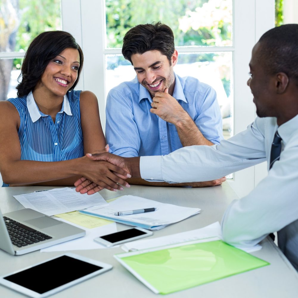 happy-couple-shaking-hands-with-real-estate-agent.jpg